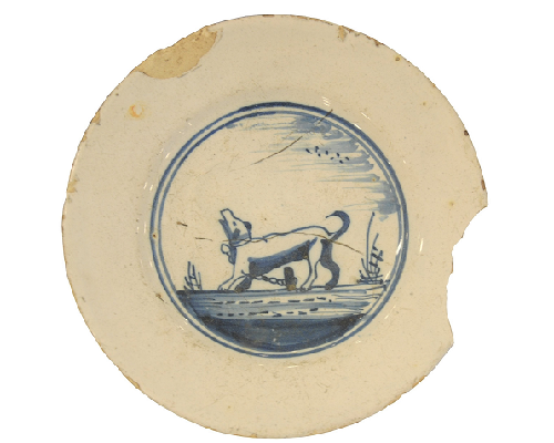 Foto van een faience bord met hondje uit de Nieuwe Tijd